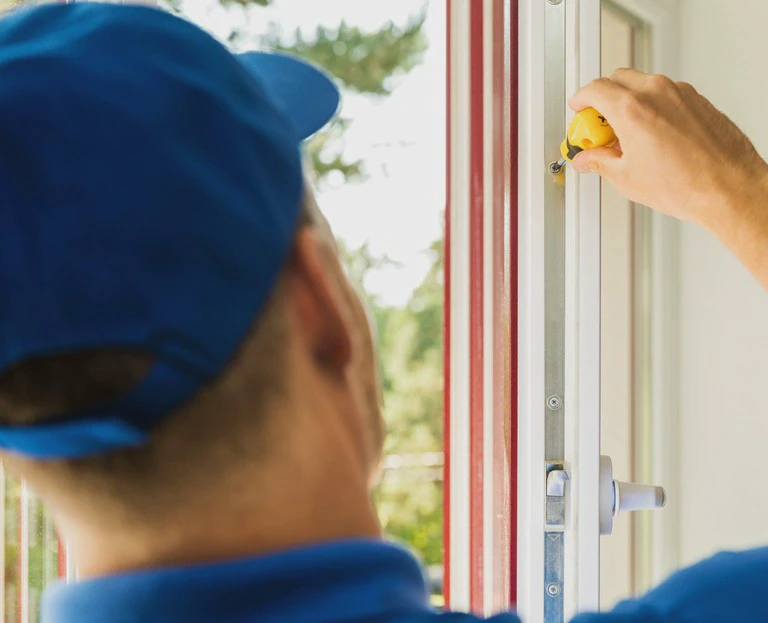 Mężczyzna naprawia okno